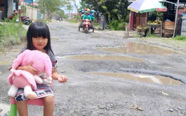 Model Cilik Di Kerinci Main Air di Jalan yang Rusak